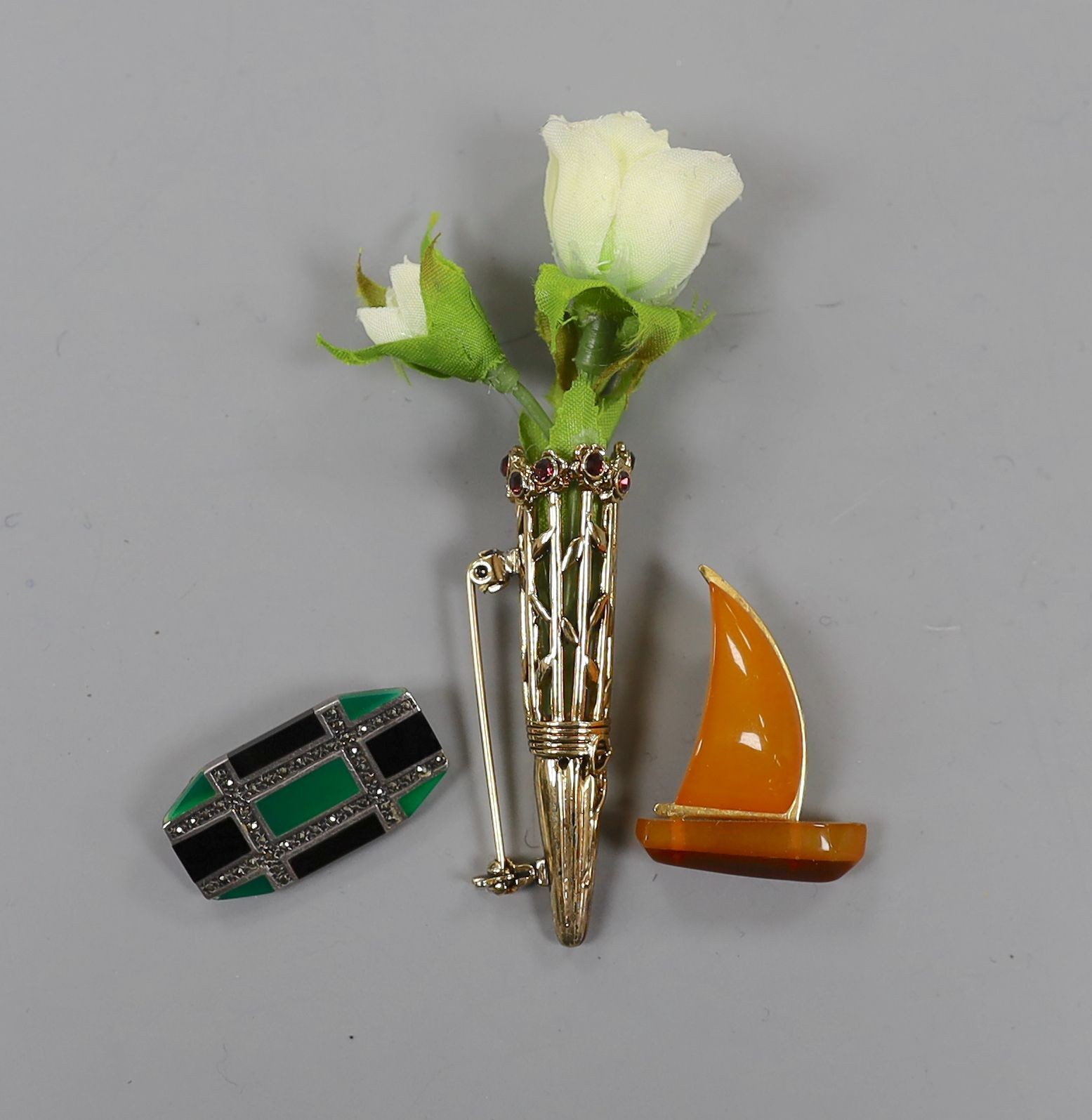 An Art Deco 925, black onyx, chrysoprase? and marcasite set octagonal brooch, 30mm, an amberoid yacht brooch and a gilt metal and paste set posy holder brooch.